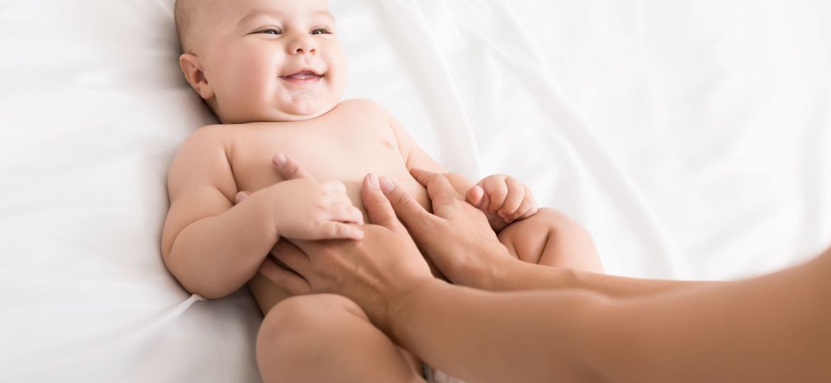 Masseur massaging tummy of baby during colic